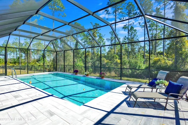 outdoor pool featuring glass enclosure and a patio area