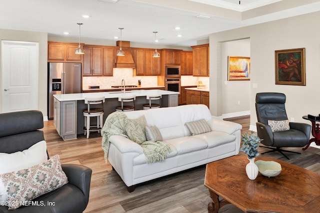 living area with light wood-style floors, baseboards, and recessed lighting