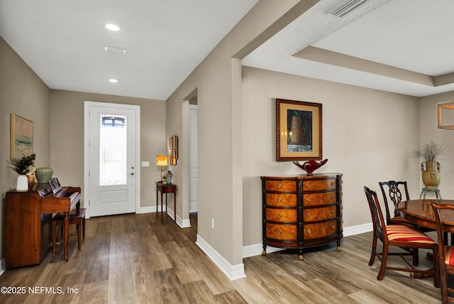 foyer with visible vents, baseboards, wood finished floors, and recessed lighting