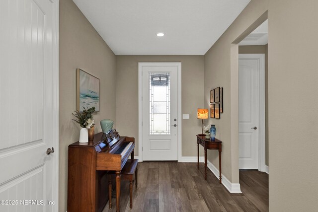 foyer featuring dark wood-type flooring and baseboards