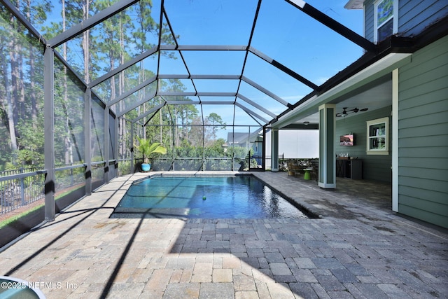 outdoor pool with a lanai, ceiling fan, and a patio area