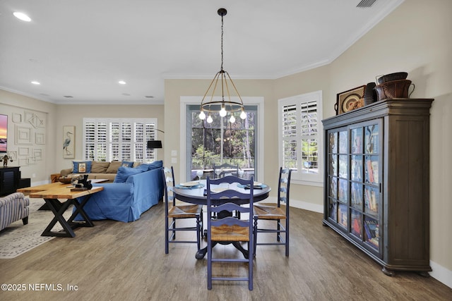 dining room featuring a notable chandelier, a healthy amount of sunlight, and wood finished floors