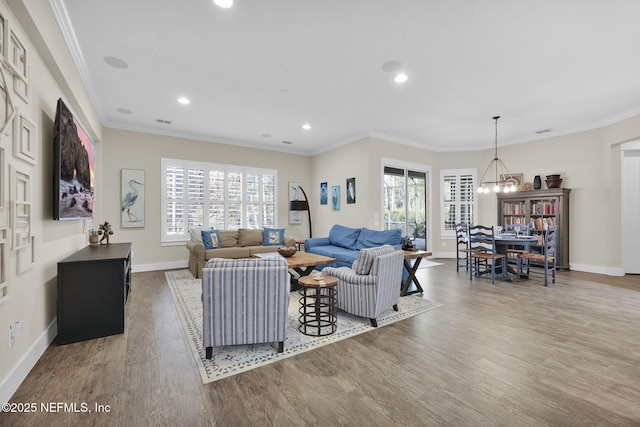 living room with wood finished floors, a wealth of natural light, and ornamental molding