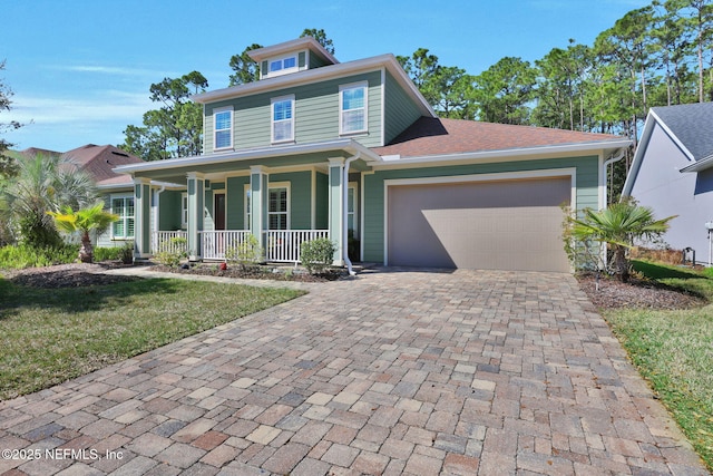 view of front of home featuring a porch, decorative driveway, and a garage