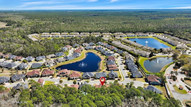 aerial view featuring a residential view, a water view, and a view of trees