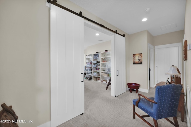 hall with recessed lighting, a barn door, and light colored carpet
