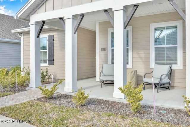 property entrance featuring covered porch and board and batten siding