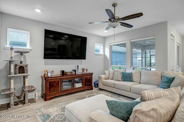 living room featuring a healthy amount of sunlight, baseboards, and wood finished floors