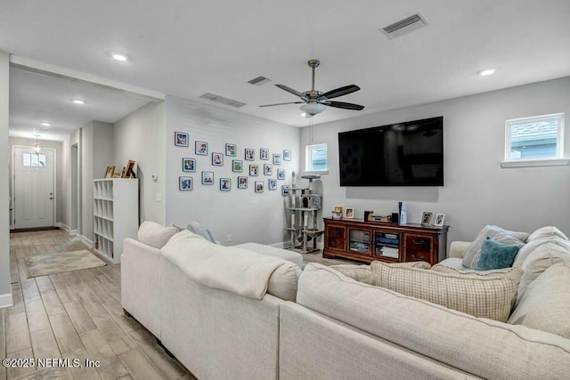 living area with light wood-type flooring, ceiling fan, visible vents, and recessed lighting