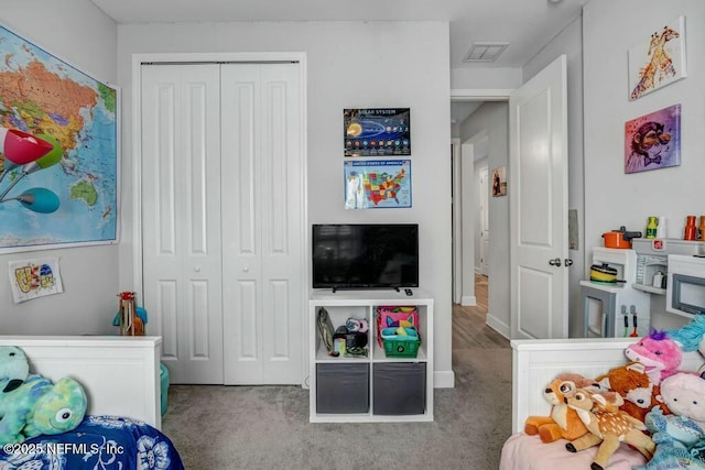 carpeted bedroom featuring a closet and visible vents