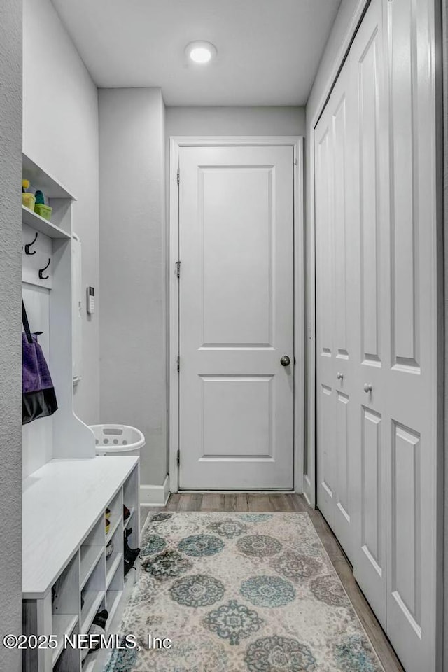 mudroom featuring light wood-style flooring and baseboards