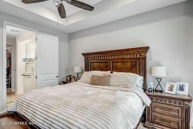 bedroom featuring ceiling fan, a closet, a walk in closet, and connected bathroom