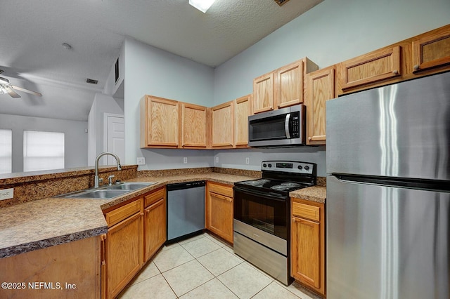 kitchen featuring light tile patterned floors, ceiling fan, appliances with stainless steel finishes, a textured ceiling, and a sink