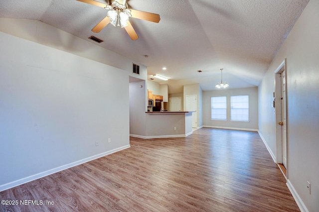 unfurnished living room with visible vents, vaulted ceiling, and wood finished floors