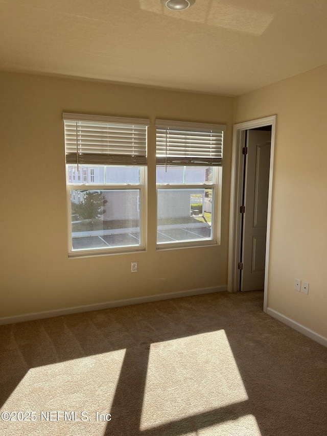 unfurnished room with carpet and baseboards