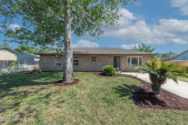 single story home with brick siding, fence, and a front yard