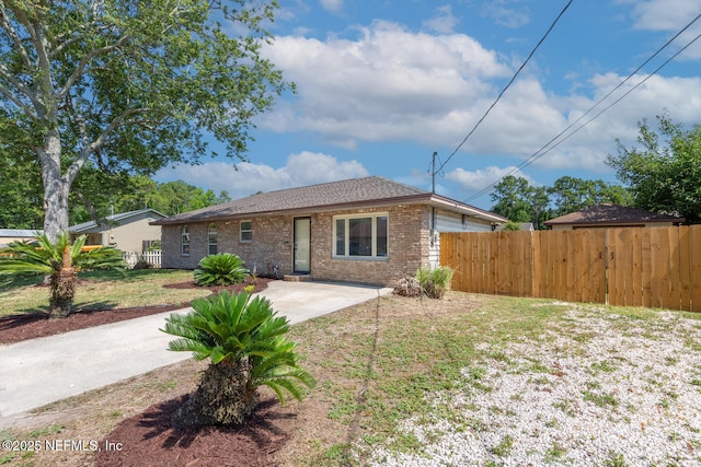 view of front facade with a front yard, brick siding, fence, and a patio