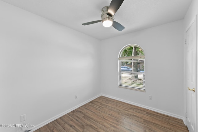 spare room with ceiling fan, baseboards, and wood finished floors