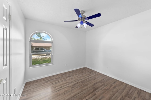 empty room with ceiling fan, wood finished floors, and baseboards