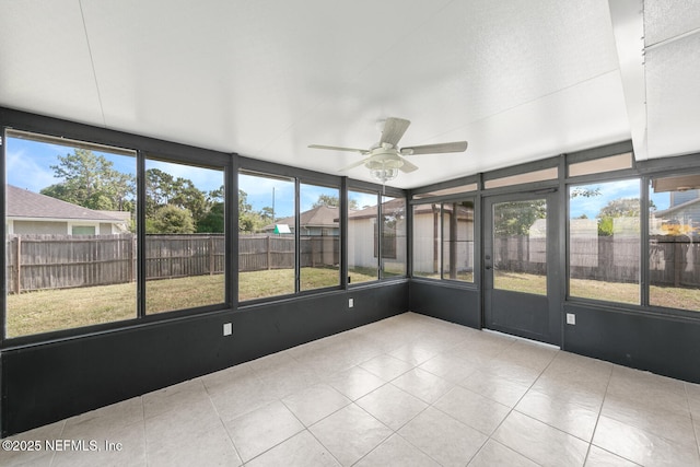 unfurnished sunroom featuring ceiling fan