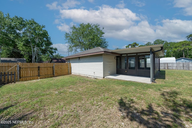 back of house with a sunroom, a patio area, a fenced backyard, and a lawn