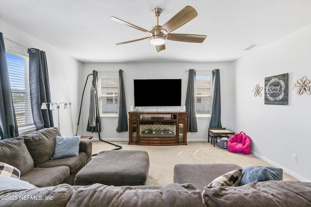 living area with carpet floors, baseboards, visible vents, and a ceiling fan