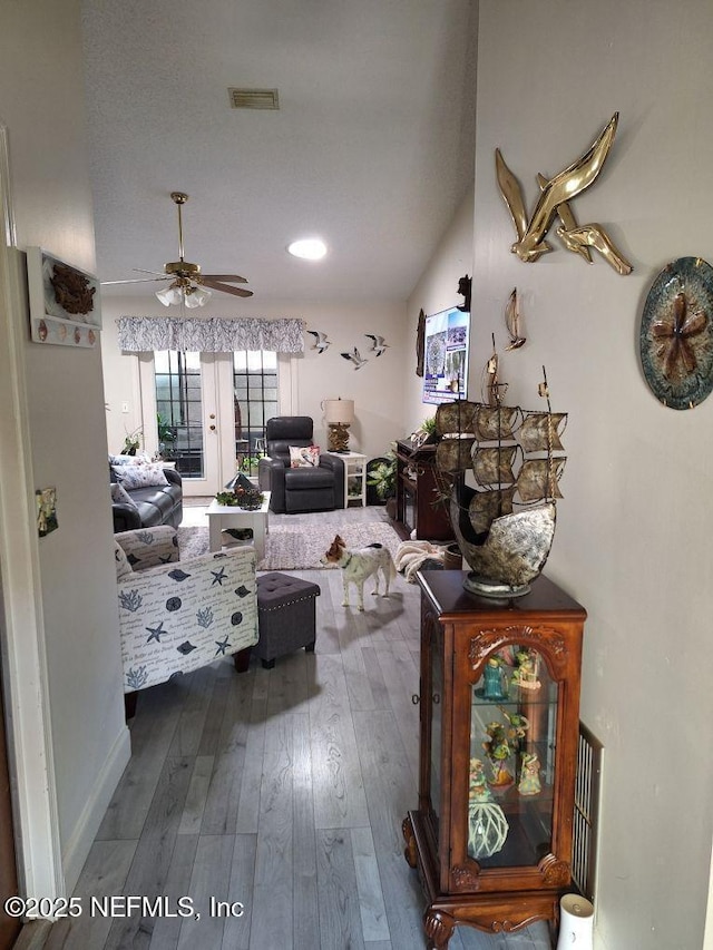 living area featuring visible vents, ceiling fan, and hardwood / wood-style flooring