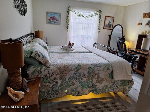 bedroom with wood finished floors and access to exterior