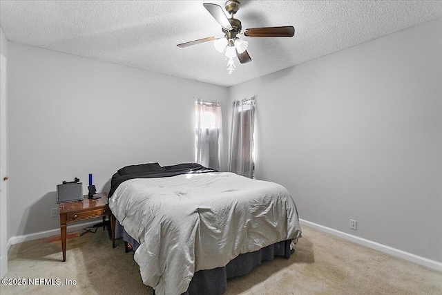 bedroom with baseboards, light colored carpet, a ceiling fan, and a textured ceiling