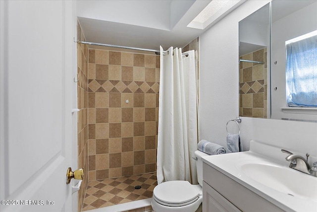 bathroom with vanity, a skylight, toilet, and a stall shower