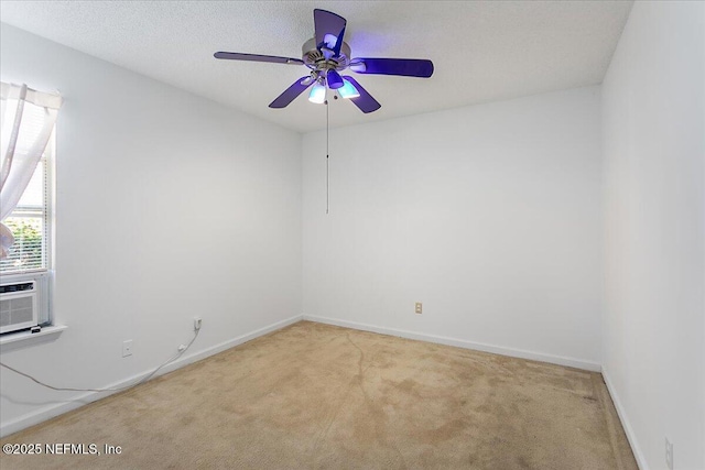 unfurnished room featuring light colored carpet, a ceiling fan, and baseboards