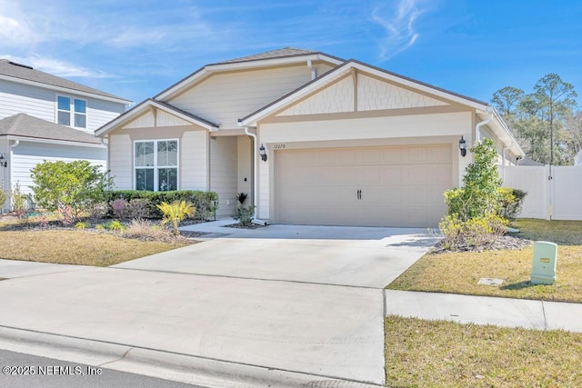 view of front facade featuring a garage, concrete driveway, and fence