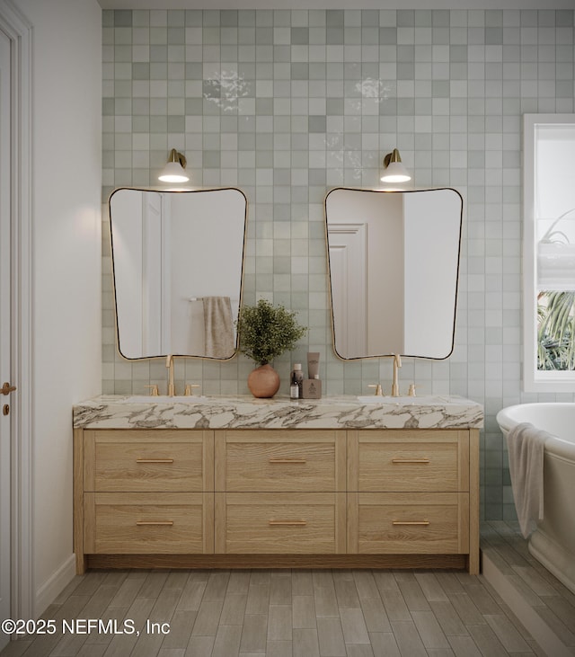 bathroom featuring double vanity, a soaking tub, tile walls, and wood finish floors