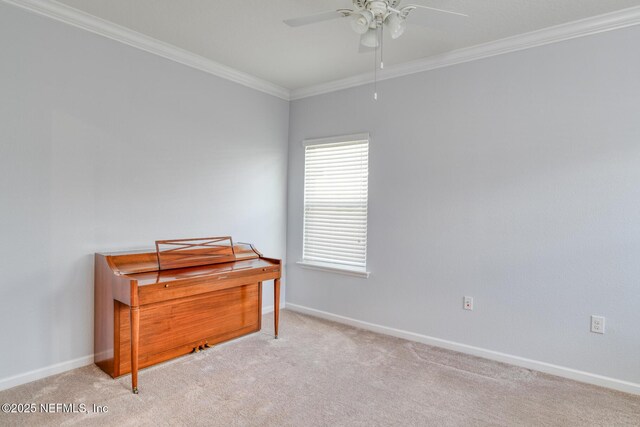 interior space with carpet, ornamental molding, ceiling fan, and baseboards