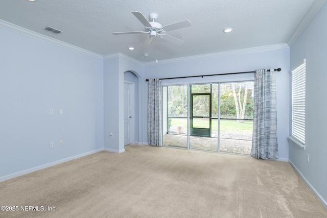 spare room with light carpet, visible vents, arched walkways, a textured ceiling, and crown molding