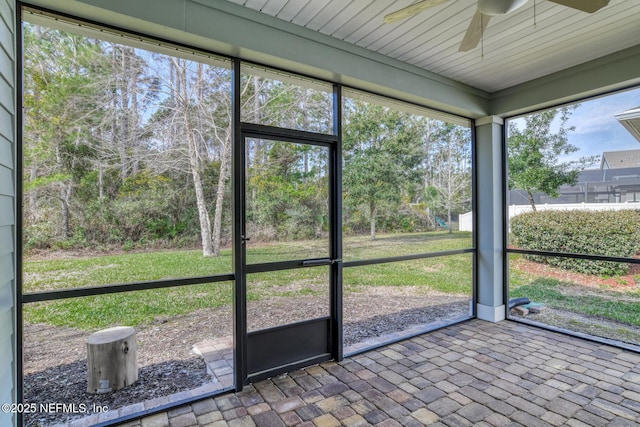 unfurnished sunroom featuring a ceiling fan