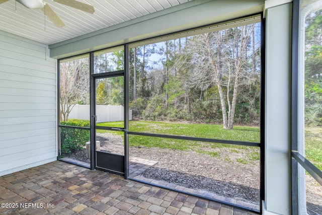 unfurnished sunroom featuring a healthy amount of sunlight and a ceiling fan