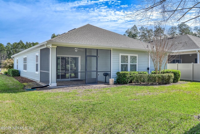 rear view of property with a yard, a shingled roof, fence, and a sunroom