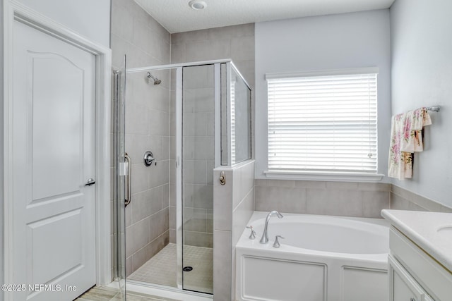 full bath featuring a stall shower, vanity, and a bath