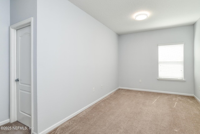 spare room featuring a textured ceiling, baseboards, and carpet flooring