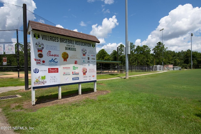 view of home's community with fence and a lawn