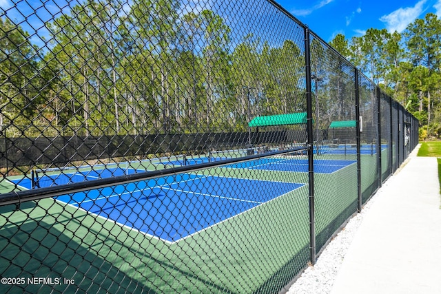 view of tennis court featuring fence