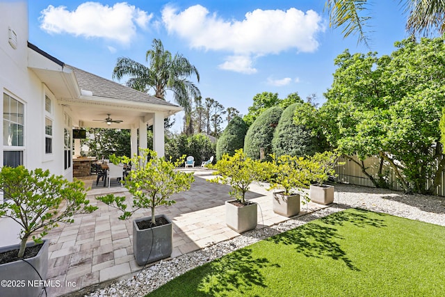 view of patio featuring ceiling fan and fence