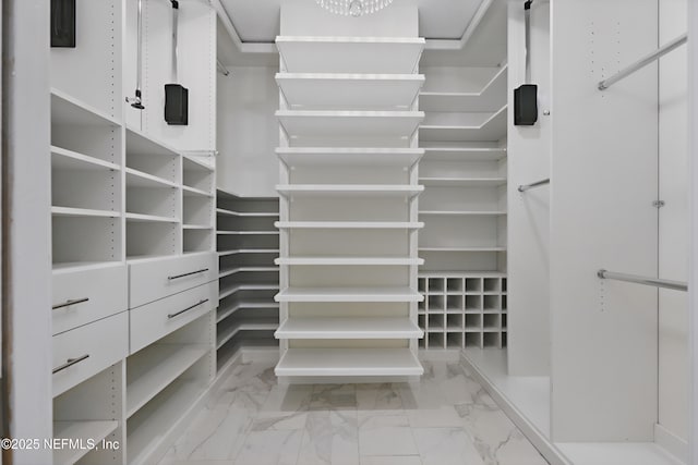 walk in closet featuring marble finish floor