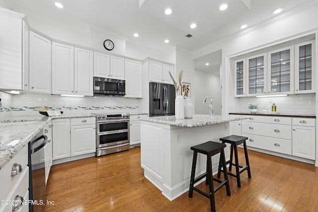 kitchen with dishwasher, white cabinets, refrigerator with ice dispenser, and double oven range