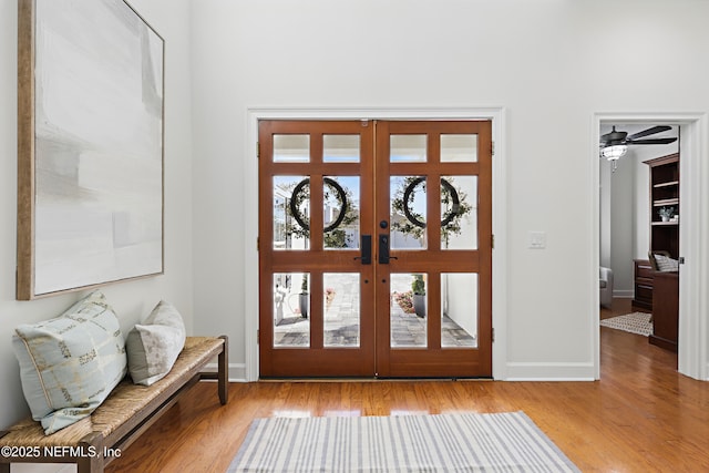 foyer featuring ceiling fan, french doors, baseboards, and wood finished floors