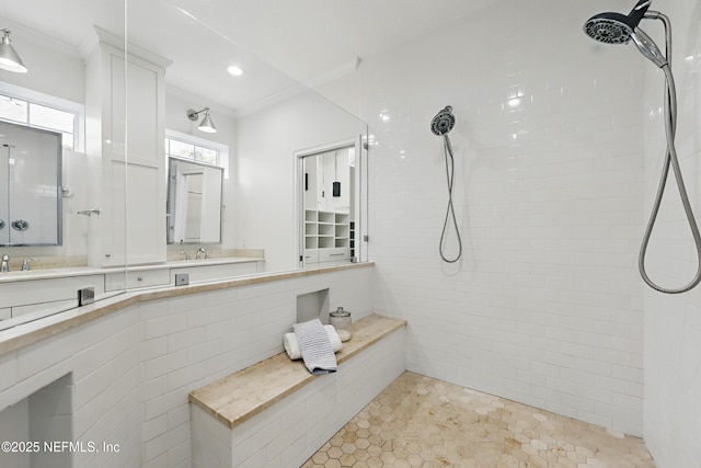 full bathroom with double vanity, recessed lighting, a tile shower, a sink, and ornamental molding