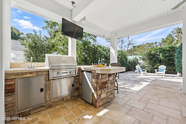 view of patio / terrace with a sink, outdoor wet bar, and area for grilling