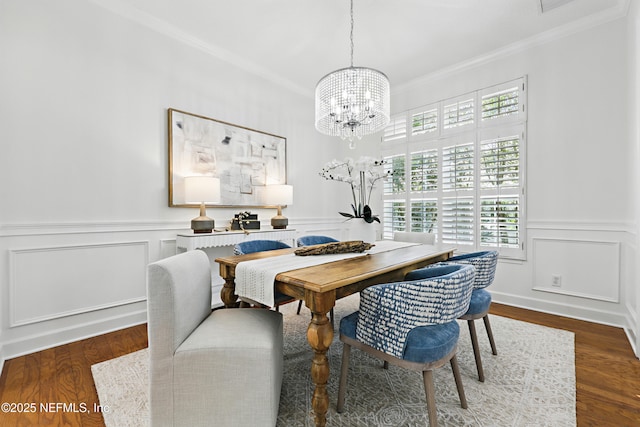 dining room featuring a notable chandelier, wainscoting, crown molding, and wood finished floors