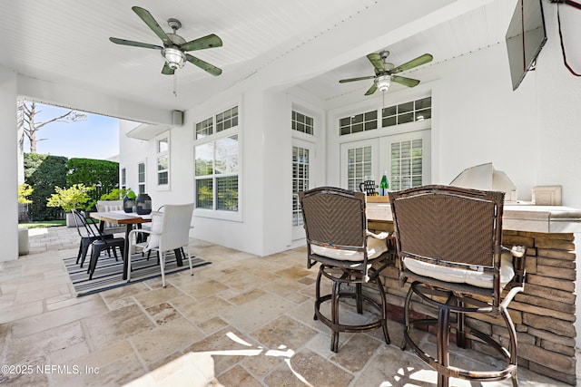 view of patio / terrace with outdoor dining space, exterior kitchen, ceiling fan, french doors, and outdoor dry bar